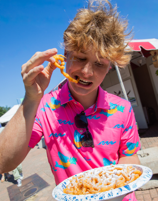 Girl holding a large funnel cake at the Red River Revel.